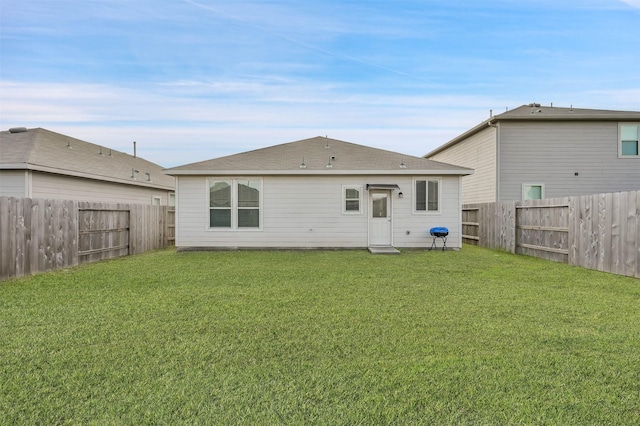 rear view of house featuring a yard