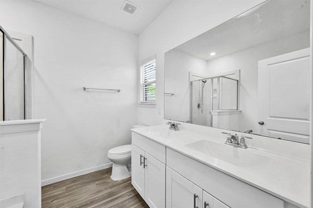 bathroom with hardwood / wood-style flooring, vanity, toilet, and walk in shower