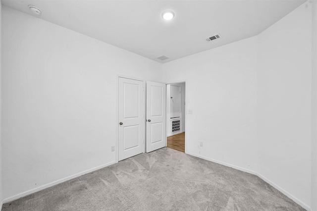 unfurnished room featuring light colored carpet