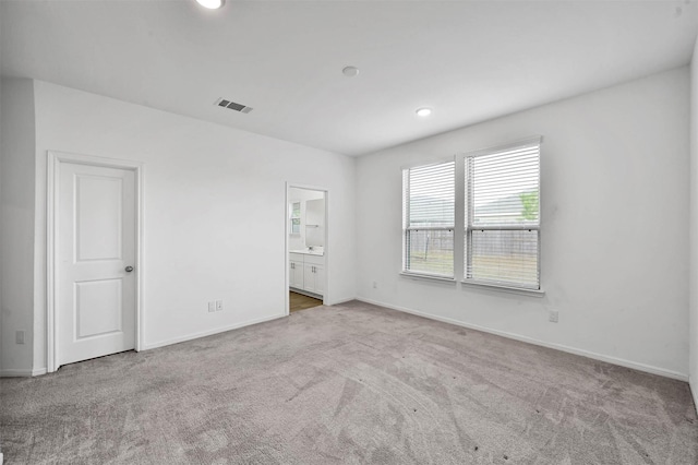 unfurnished bedroom with carpet flooring and ensuite bath