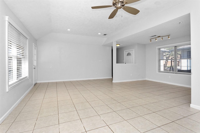 unfurnished room with ceiling fan, lofted ceiling, a textured ceiling, and rail lighting