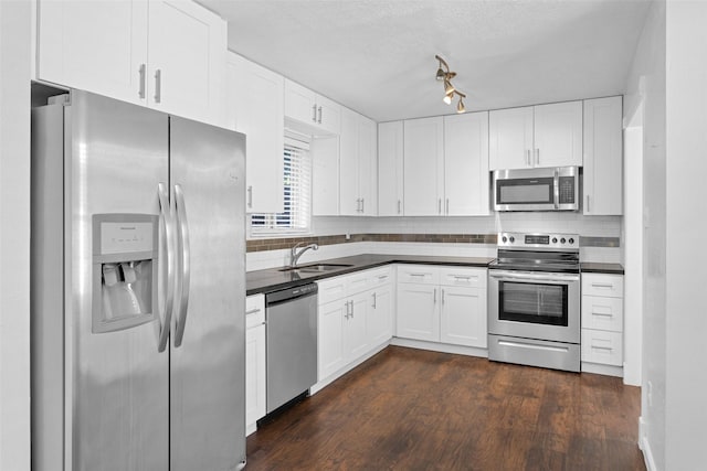 kitchen featuring white cabinetry, sink, dark wood-type flooring, and appliances with stainless steel finishes