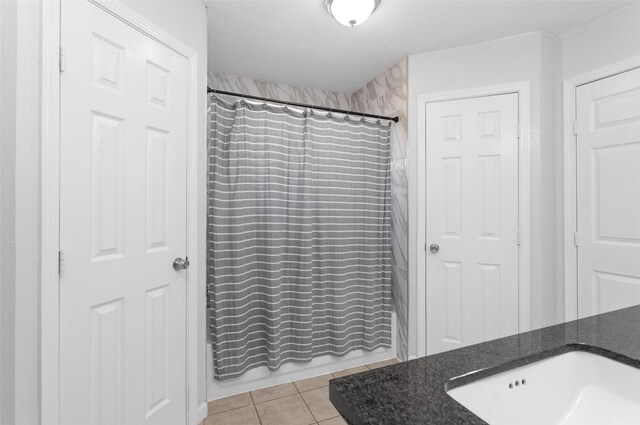 bathroom featuring tile patterned floors, shower / bath combo with shower curtain, and vanity