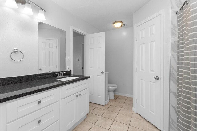 bathroom featuring tile patterned flooring, vanity, and toilet