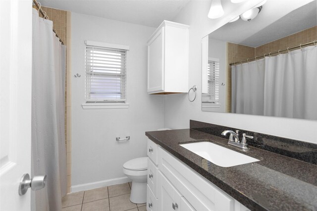 bathroom featuring tile patterned flooring, vanity, curtained shower, and toilet