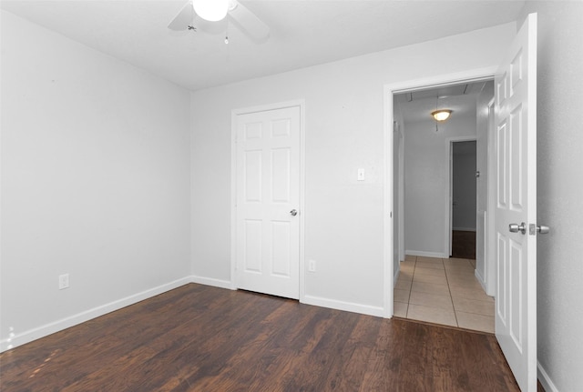 unfurnished bedroom featuring a closet, ceiling fan, and dark wood-type flooring