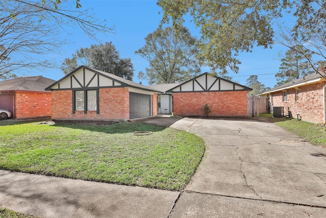 english style home featuring a garage, a front lawn, and central air condition unit