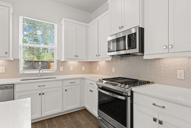 kitchen with stainless steel appliances, white cabinetry, tasteful backsplash, and sink