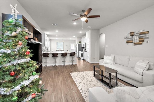 living room featuring ceiling fan and light wood-type flooring