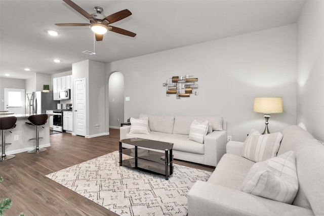 living room with light hardwood / wood-style floors and ceiling fan