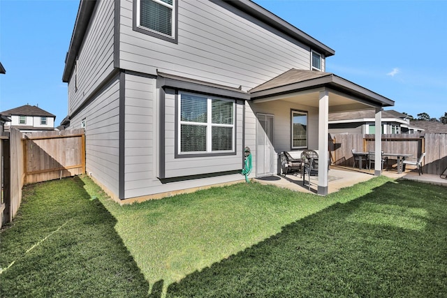 rear view of house with a lawn and a patio area