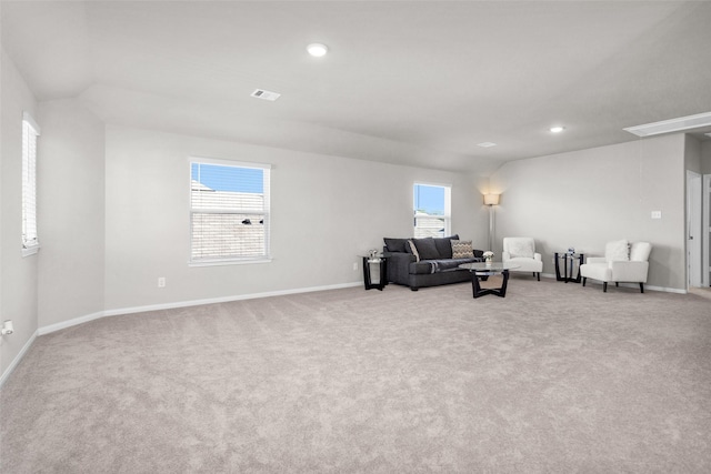 living room with plenty of natural light, light colored carpet, and lofted ceiling