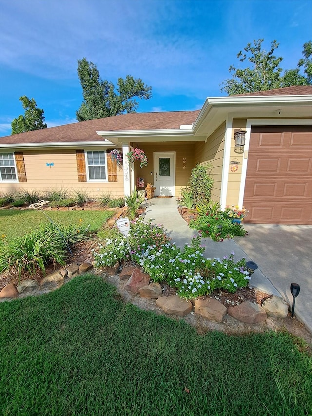 single story home with a garage and a front lawn