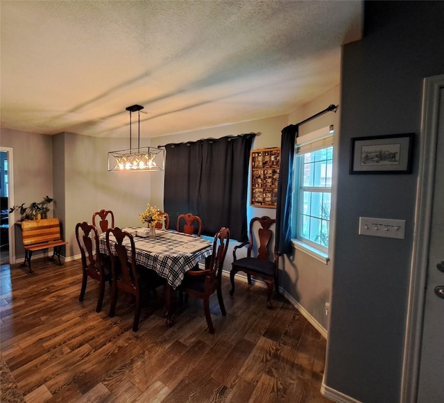 dining room featuring dark hardwood / wood-style flooring and a textured ceiling