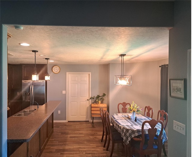 dining room featuring a textured ceiling, dark hardwood / wood-style floors, and sink