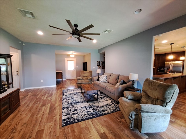 living room featuring light wood-type flooring and ceiling fan