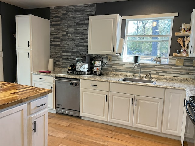 kitchen featuring dishwasher, sink, light hardwood / wood-style flooring, decorative backsplash, and white cabinetry