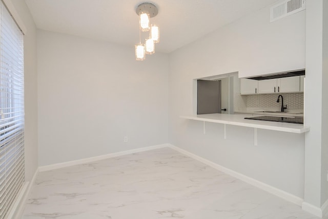 unfurnished dining area with a chandelier and sink