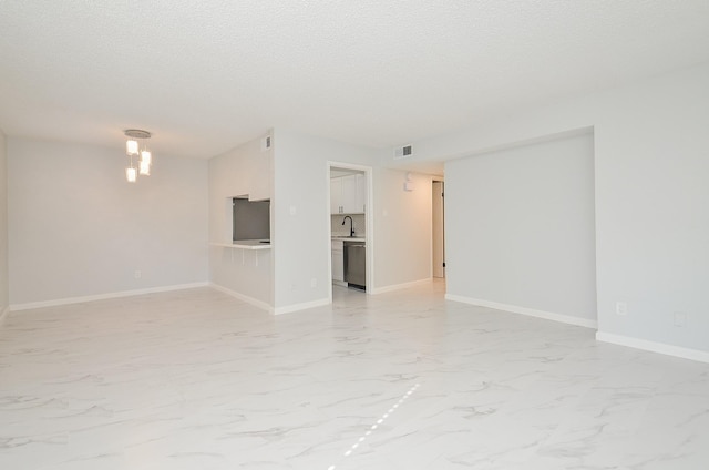 empty room with a textured ceiling and sink