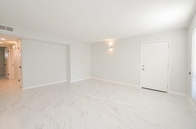 unfurnished room with a textured ceiling