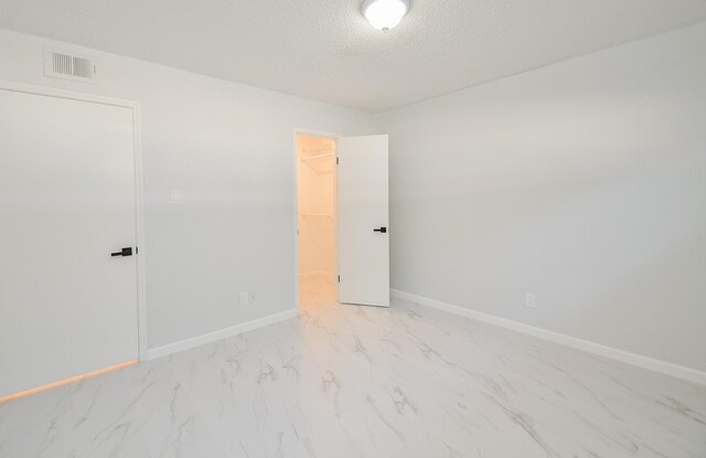 unfurnished room with a textured ceiling