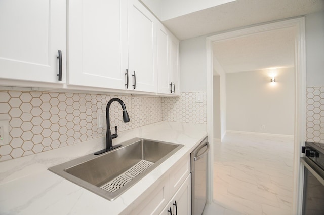 kitchen with white cabinets, dishwasher, tasteful backsplash, and sink