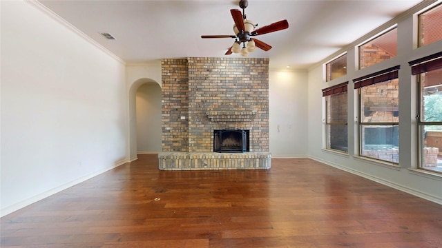 unfurnished living room featuring ceiling fan, a fireplace, wood-type flooring, and crown molding