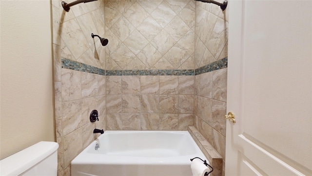 bathroom featuring toilet and tiled shower / bath