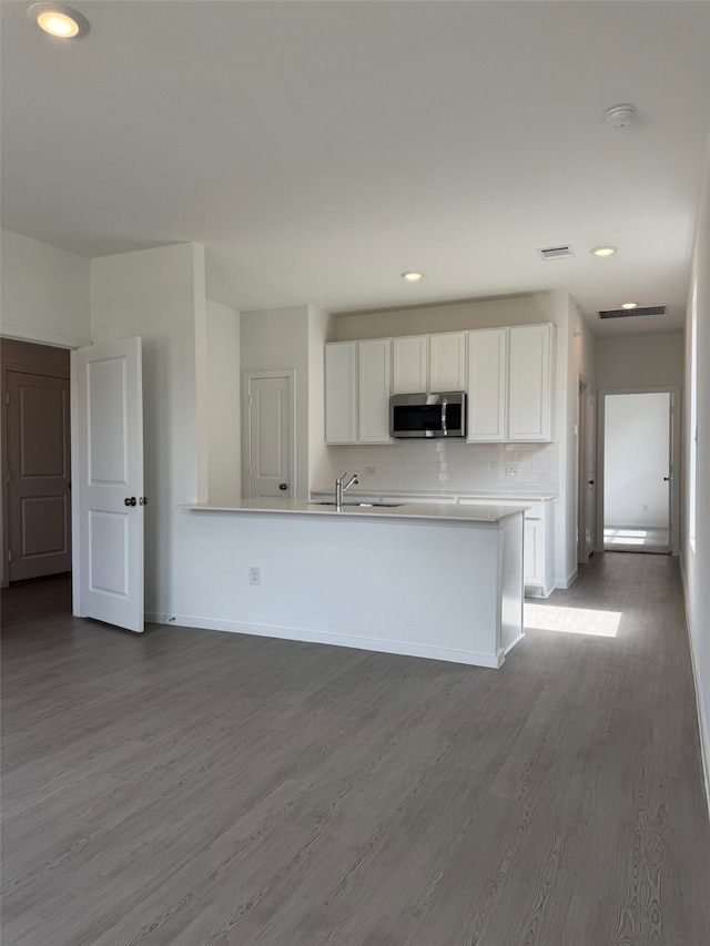 3020 Ruby Ridge Dr, Katy, TX 77493 - kitchen featuring stainless steel microwave, white cabinetry, wood finished floors, recessed lighting, and light countertops