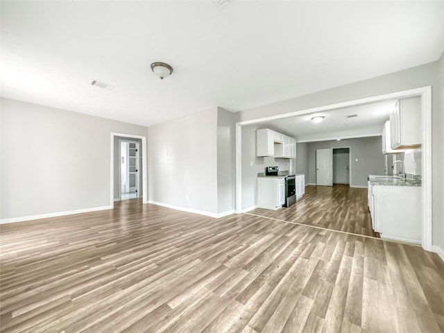 unfurnished living room featuring light hardwood / wood-style flooring and sink