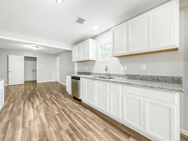 kitchen with sink, light hardwood / wood-style flooring, stainless steel dishwasher, light stone counters, and white cabinetry