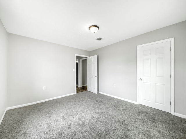 unfurnished bedroom with dark carpet