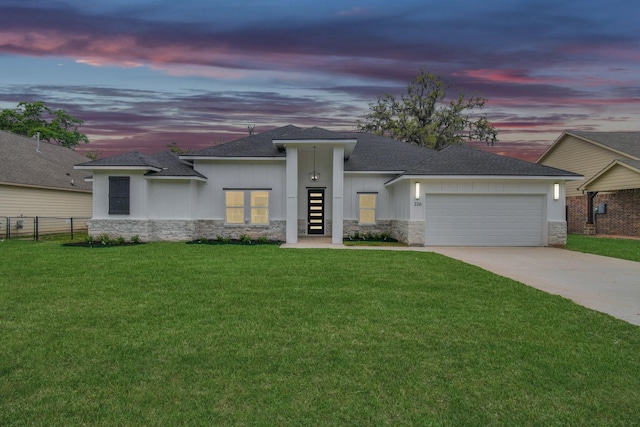 prairie-style home featuring a yard and a garage