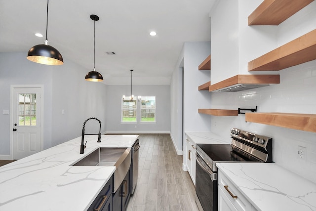 kitchen with decorative light fixtures, light stone counters, white cabinetry, and appliances with stainless steel finishes