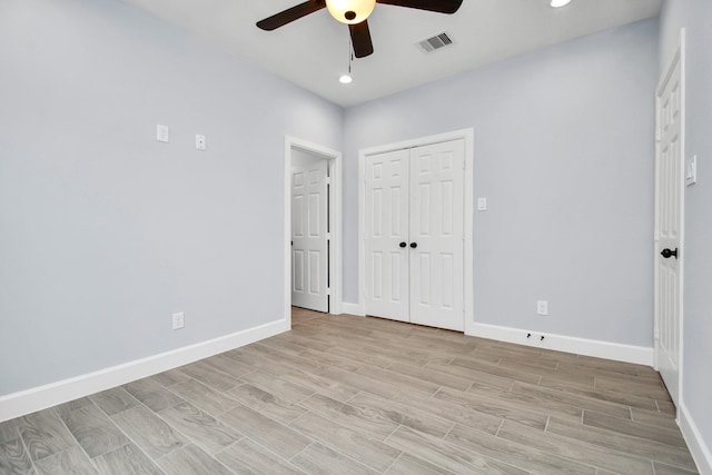 unfurnished bedroom with ceiling fan and a closet