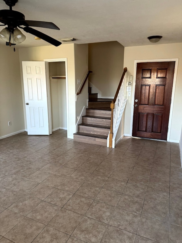 foyer entrance with tile patterned floors and ceiling fan