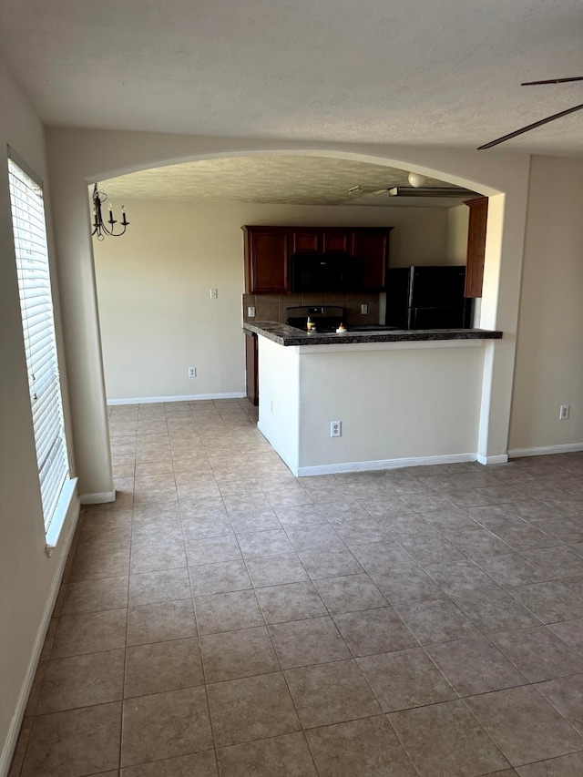 kitchen featuring black appliances, light tile patterned floors, and kitchen peninsula