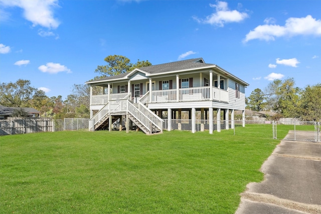 rear view of house featuring a lawn and covered porch