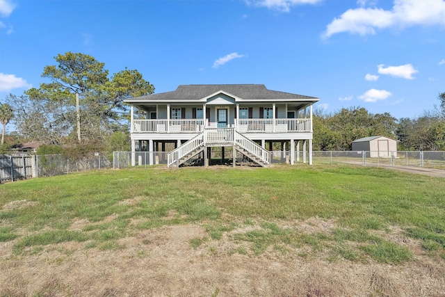 beach home featuring a front lawn and covered porch