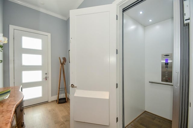 interior space with light hardwood / wood-style floors, crown molding, and elevator