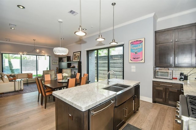 kitchen with dishwasher, a center island with sink, sink, range with gas stovetop, and dark brown cabinets