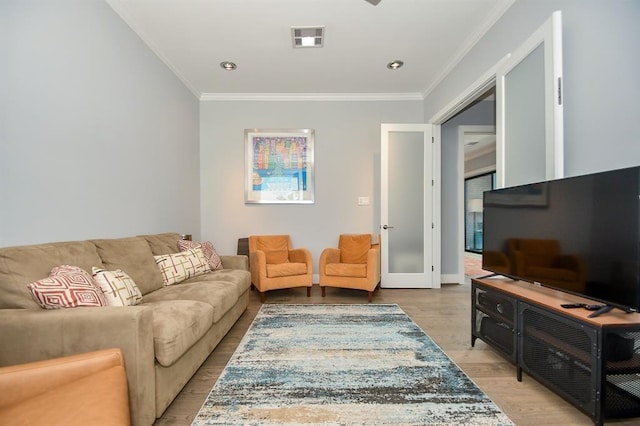 living room featuring light hardwood / wood-style floors and crown molding