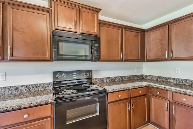 kitchen featuring black appliances and dark stone countertops