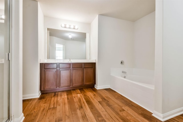 bathroom featuring hardwood / wood-style floors, vanity, and a tub