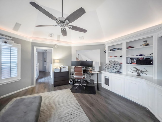 office area featuring built in shelves, a tray ceiling, vaulted ceiling, ceiling fan, and dark wood-type flooring