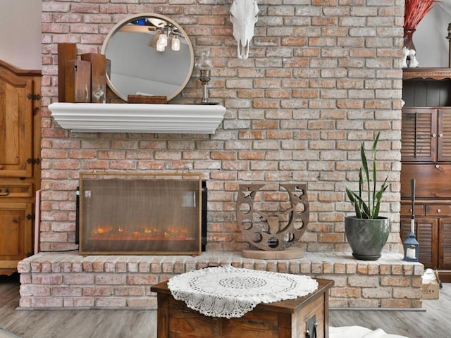 room details featuring hardwood / wood-style flooring and a brick fireplace