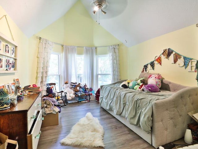 bedroom with ceiling fan, hardwood / wood-style floors, and lofted ceiling