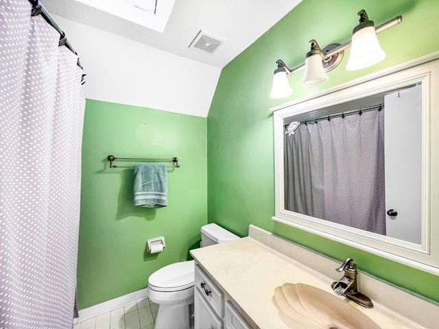 bathroom with toilet, tile patterned floors, vanity, and lofted ceiling with skylight