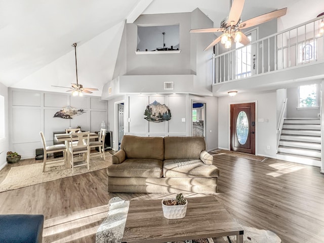 living room featuring wood-type flooring, high vaulted ceiling, and ceiling fan