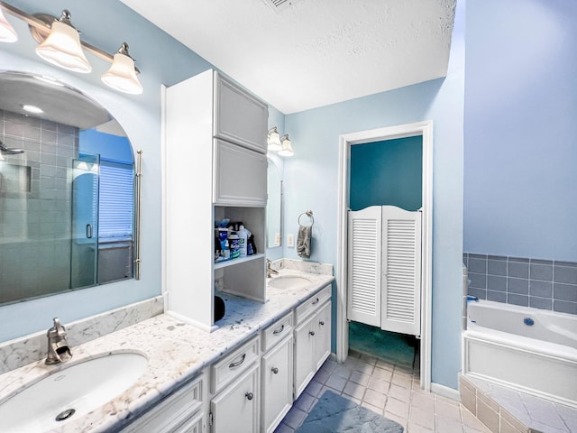 bathroom featuring separate shower and tub, tile patterned flooring, vanity, and a textured ceiling